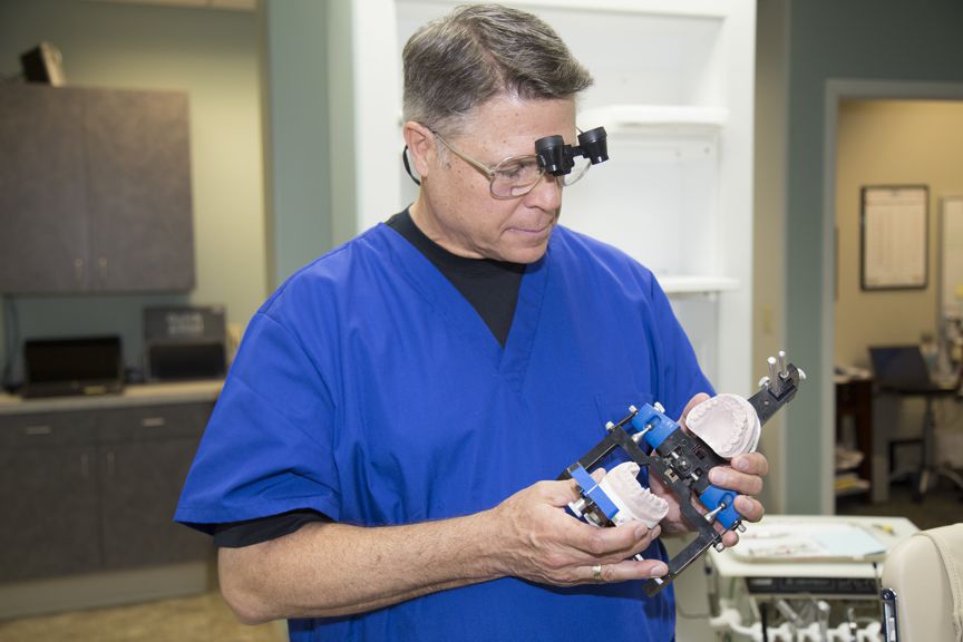 Steven Maurstad, Omaha Dentist looking at dental device 